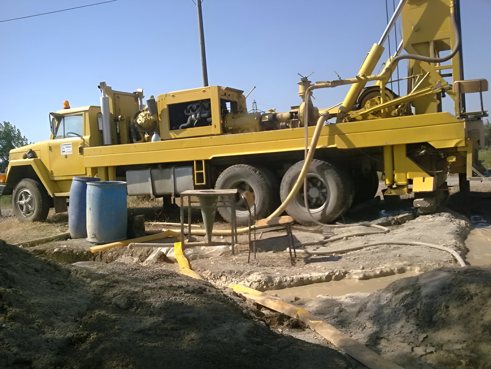 An image of a specialized water drilling vehicle equipped with machinery and tools, designed to penetrate the earth's surface to access underground water sources